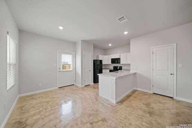 kitchen with black appliances, kitchen peninsula, white cabinetry, and sink