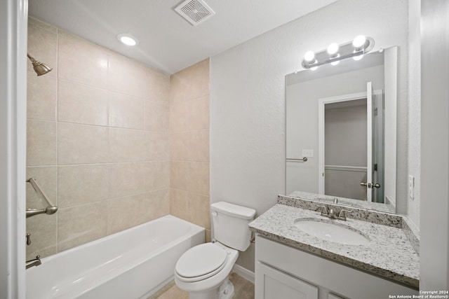 full bathroom featuring tiled shower / bath combo, vanity, and toilet