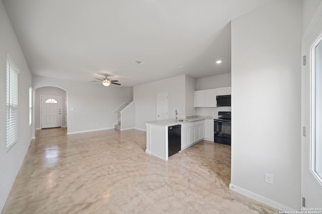 kitchen with white cabinets, sink, kitchen peninsula, black appliances, and a healthy amount of sunlight