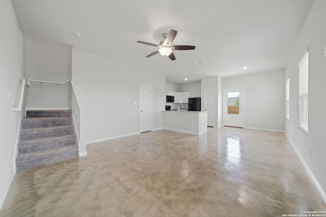 unfurnished living room with ceiling fan and sink