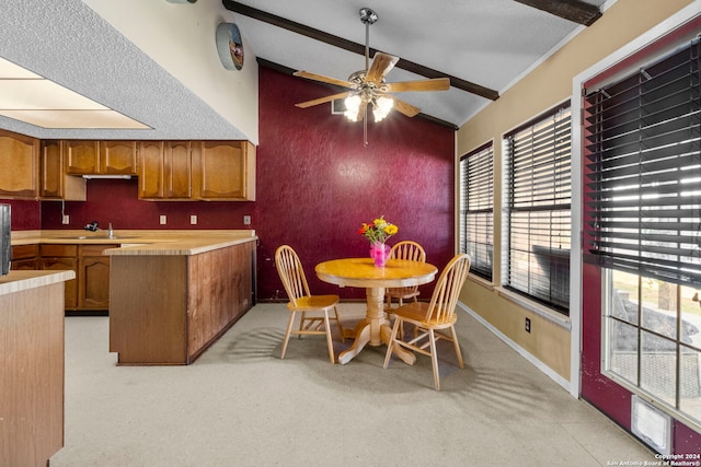 kitchen featuring lofted ceiling with beams, ceiling fan, and sink