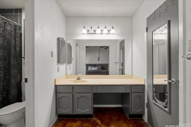 bathroom with a textured ceiling, curtained shower, vanity, and toilet