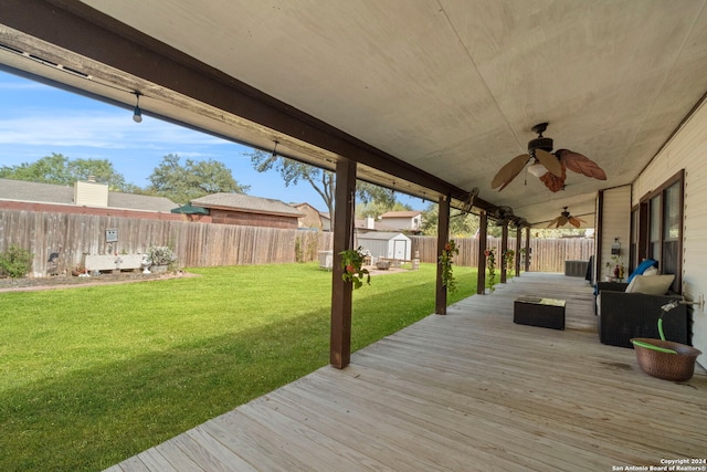 wooden deck featuring a lawn and ceiling fan