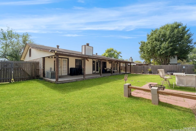 back of house with a patio, a yard, and central AC