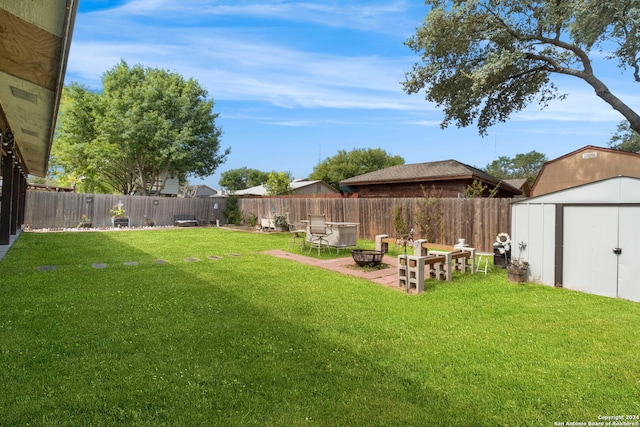 view of yard with a storage shed, a patio area, and an outdoor fire pit