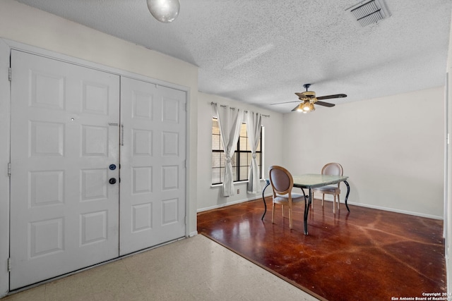 foyer with ceiling fan and a textured ceiling