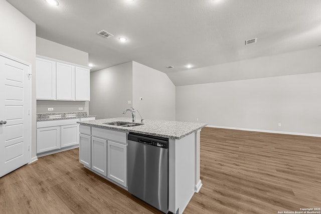 kitchen featuring stainless steel dishwasher, an island with sink, light wood-type flooring, visible vents, and a sink