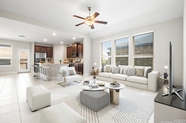 living room featuring ceiling fan, light tile patterned floors, and plenty of natural light