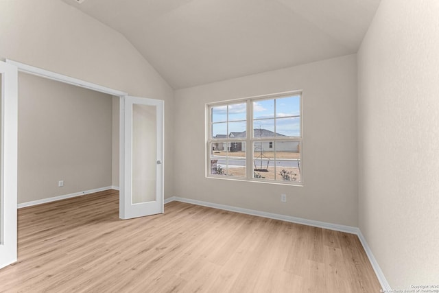 unfurnished bedroom with light wood-type flooring and lofted ceiling