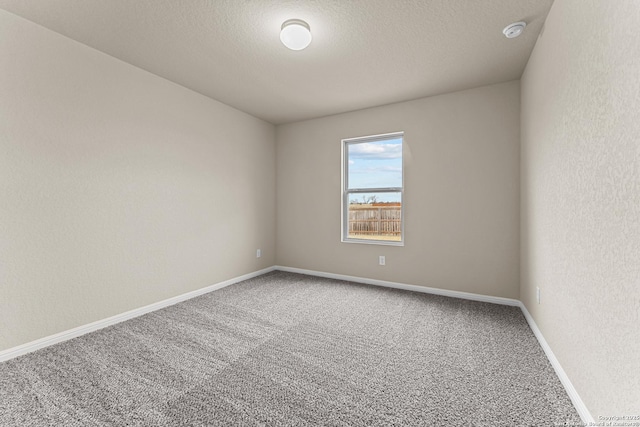 spare room featuring carpet floors and a textured ceiling