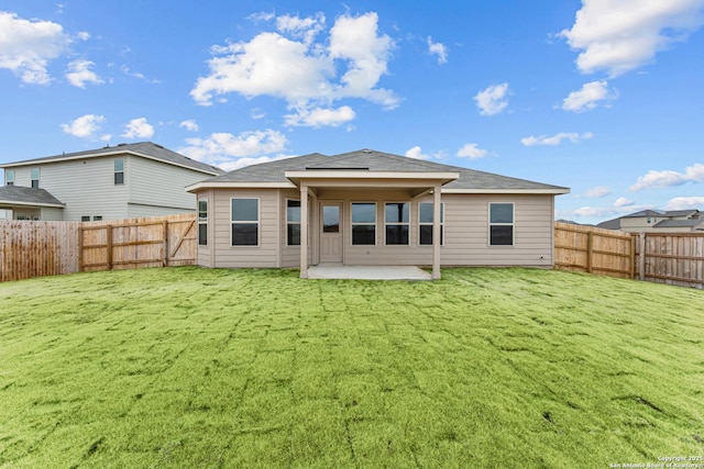 back of house with a yard and a patio