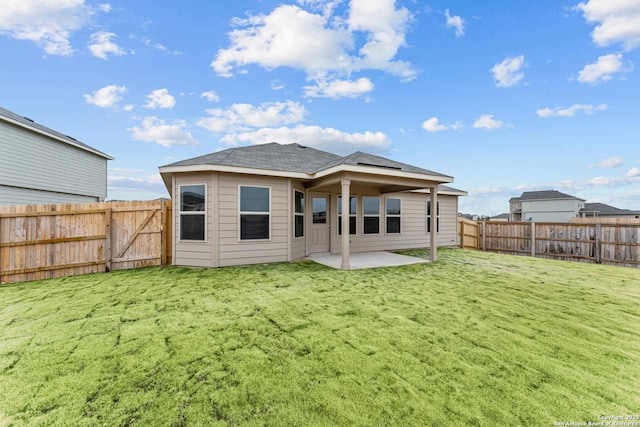 rear view of property with a lawn and a patio