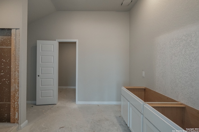 interior space featuring vaulted ceiling and white cabinetry