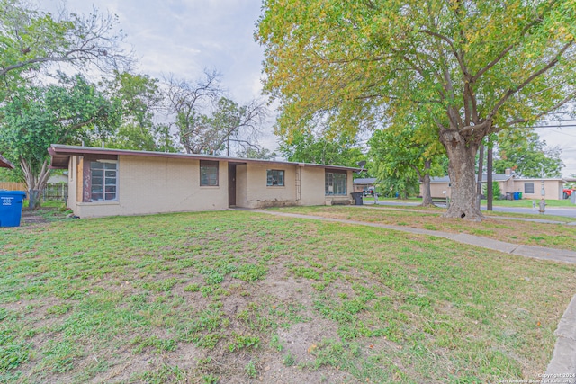 ranch-style home featuring a front lawn