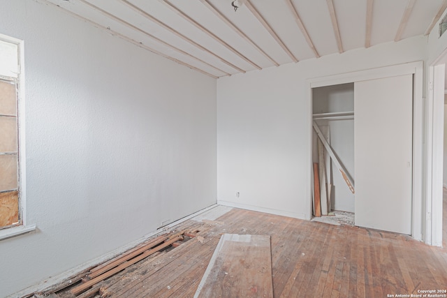 unfurnished bedroom featuring a closet and hardwood / wood-style floors