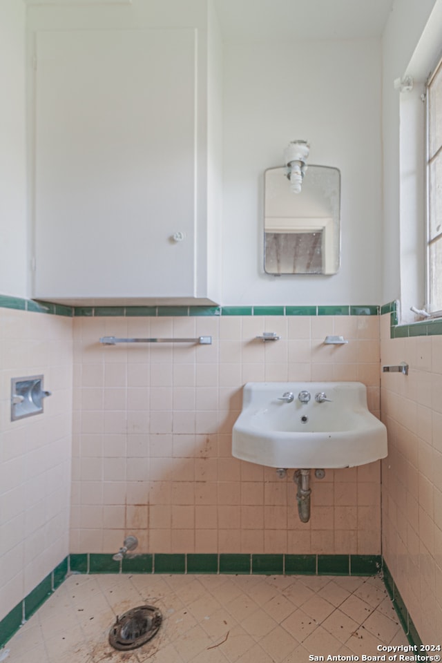 bathroom featuring tile walls and sink