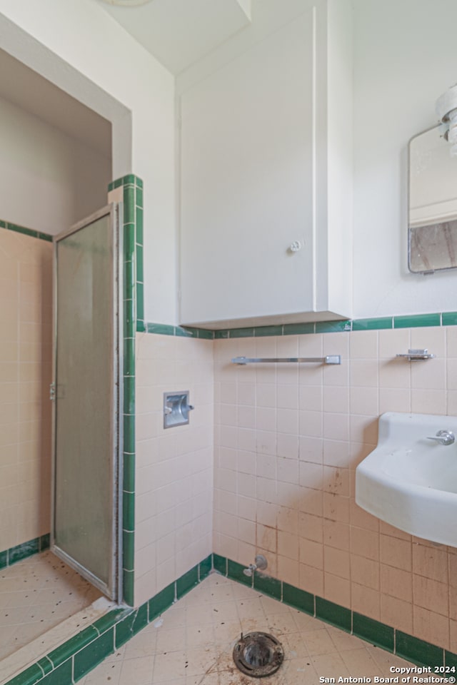 bathroom with tile patterned floors, a shower with shower door, and sink