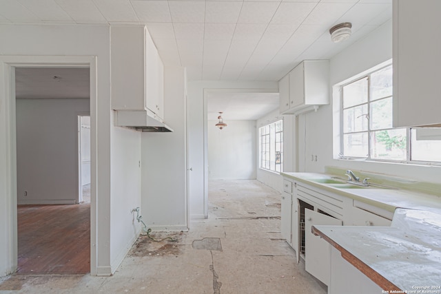 kitchen featuring light wood-type flooring, plenty of natural light, sink, and white cabinetry