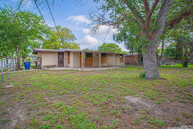 back of house featuring a yard and a patio area