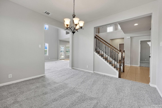 unfurnished room featuring carpet floors, stairway, a chandelier, and visible vents