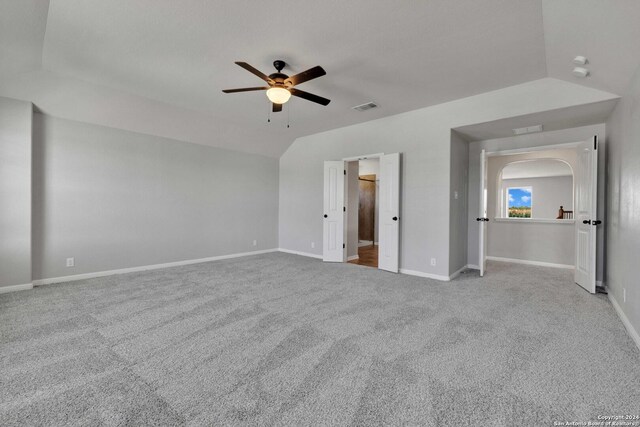 unfurnished bedroom with ceiling fan, light colored carpet, and vaulted ceiling