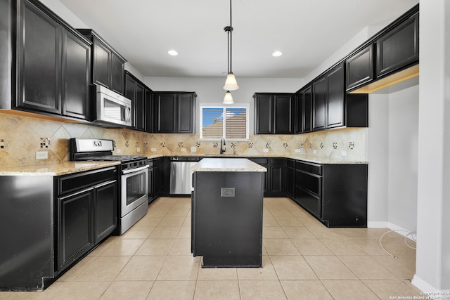 kitchen featuring pendant lighting, sink, a kitchen island, decorative backsplash, and appliances with stainless steel finishes