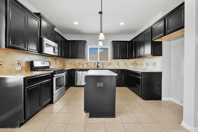 kitchen with stainless steel appliances, light tile patterned floors, a sink, and dark cabinetry
