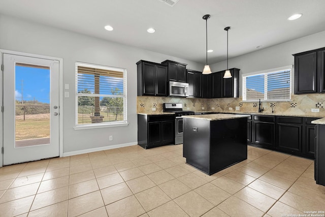 kitchen with tasteful backsplash, a sink, dark cabinetry, and appliances with stainless steel finishes