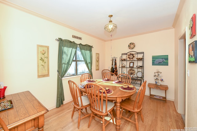 dining space featuring ornamental molding and light wood-type flooring