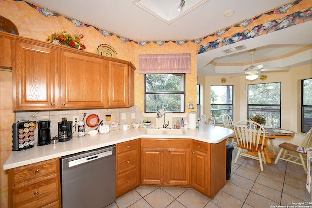 kitchen with kitchen peninsula, sink, stainless steel dishwasher, and tasteful backsplash