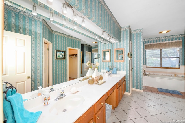 bathroom with tile patterned floors, a tub, and vanity