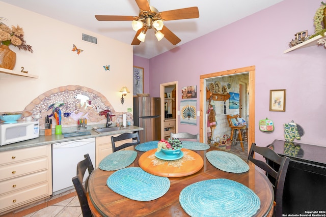 tiled dining area featuring ceiling fan and sink