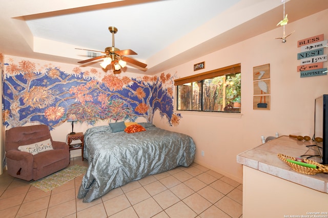 tiled bedroom featuring ceiling fan and a tray ceiling