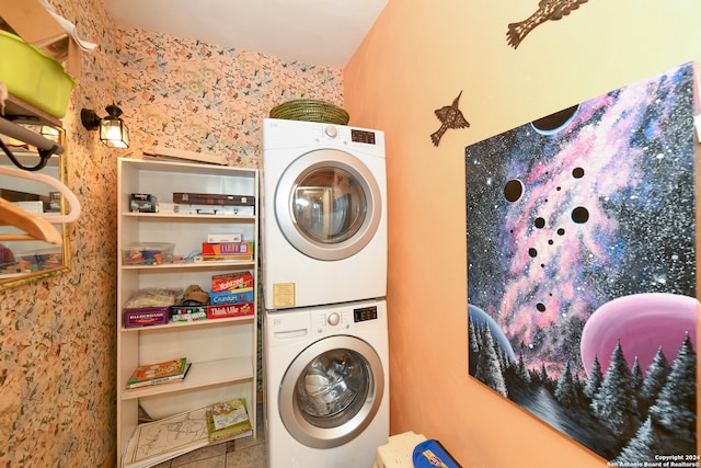 clothes washing area featuring tile patterned flooring and stacked washer / dryer