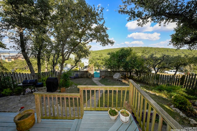 wooden deck with grilling area and a lawn