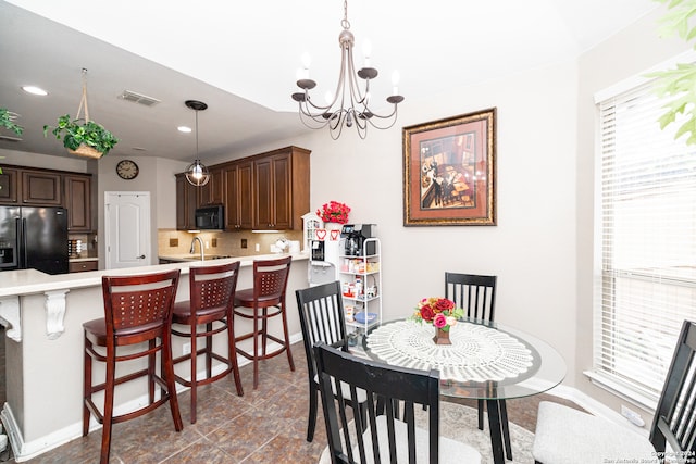 dining room with sink and a chandelier