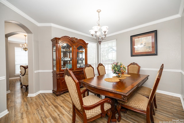 dining room featuring a chandelier, crown molding, and light hardwood / wood-style flooring