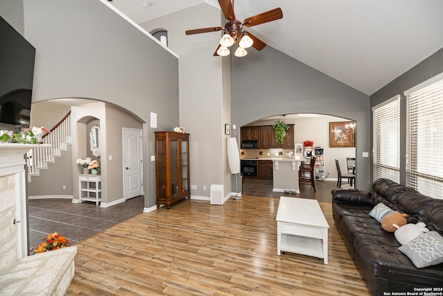 living room featuring wood-type flooring, high vaulted ceiling, sink, and ceiling fan