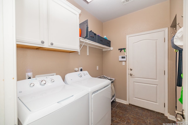 laundry area with cabinets, washer and dryer, and dark tile patterned floors