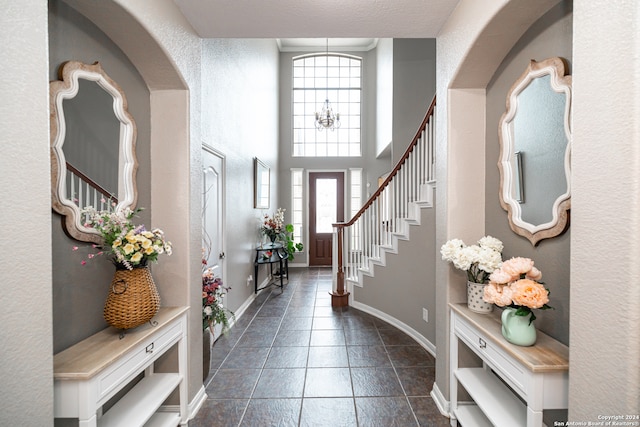 tiled entryway featuring plenty of natural light and a notable chandelier