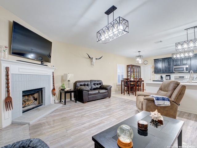 living room with light wood-type flooring and a fireplace