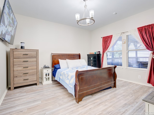 bedroom featuring a notable chandelier and light wood-type flooring