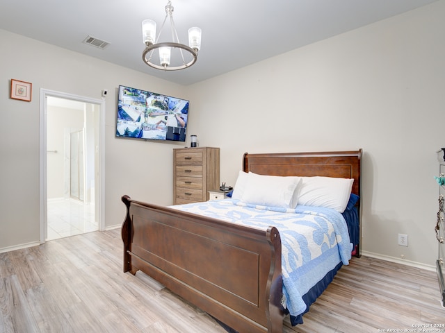 bedroom featuring an inviting chandelier and light hardwood / wood-style floors