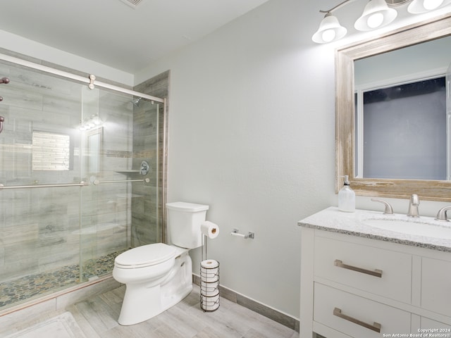 bathroom featuring walk in shower, vanity, toilet, and hardwood / wood-style flooring