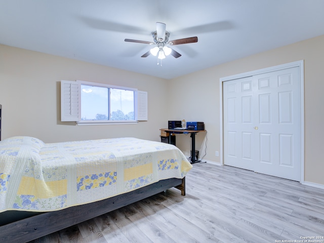 bedroom with light wood-type flooring, ceiling fan, and a closet