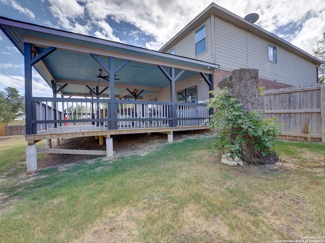 back of house featuring a wooden deck and a lawn