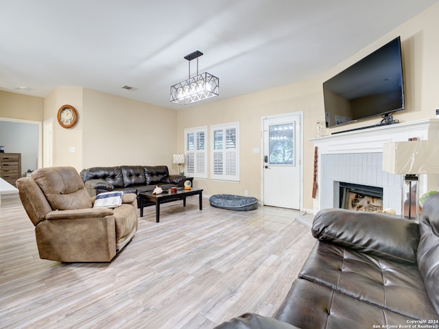 living room featuring a brick fireplace and light hardwood / wood-style floors