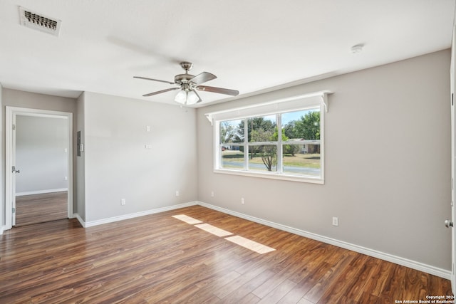 spare room with dark wood-type flooring and ceiling fan