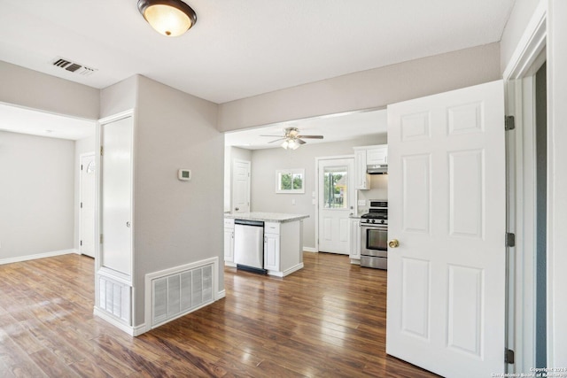 1505 B St, Floresville, TX 78114 - kitchen featuring appliances with stainless steel finishes, white cabinetry, dark wood-style flooring, and a ceiling fan