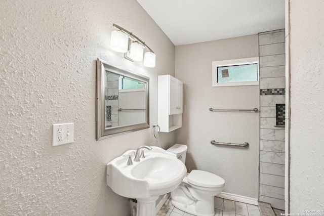 1505 B St, Floresville, TX 78114 - bathroom with toilet, a sink, a textured wall, and baseboards